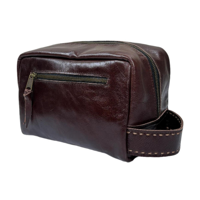 Dark brown premium leather shave bag with a side handle, hand-stitched details, and a zippered front compartment.