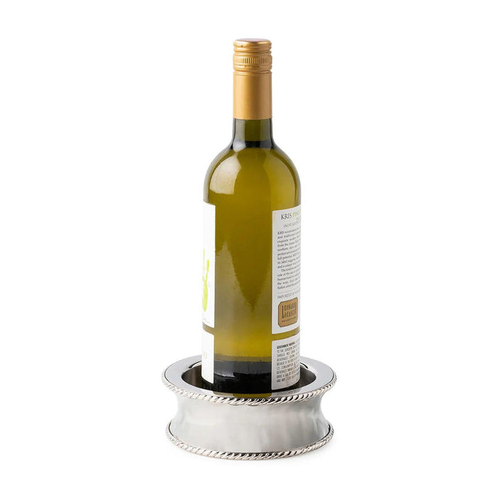 Hammered stainless steel Juliska Graham wine coaster with decorative thread trim detailing holding a wine bottle.