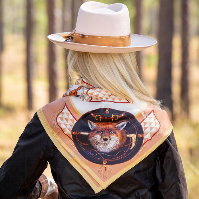 Woman wearing a 36-inch square silk scarf featuring a fox hunt design with hand-rolled edges and elegant tan accents.