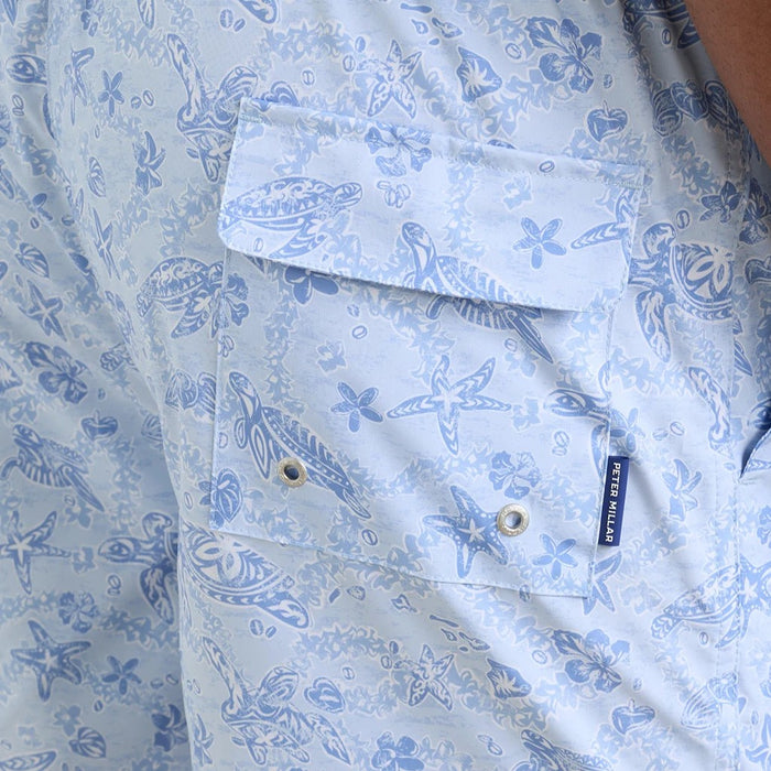 Light blue Peter Millar swim trunks with a white sea turtle and starfish print, featuring a flap pocket and side label.