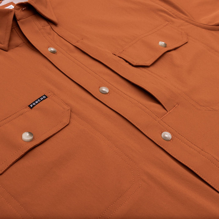 Smokey orange short sleeve performance shirt featuring dual chest pockets, branded label, and button-down front.