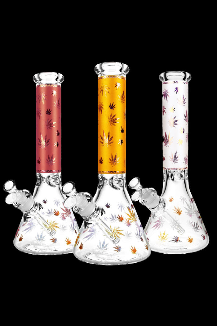 Three patterned glass bongs with cannabis leaf designs against a black background.