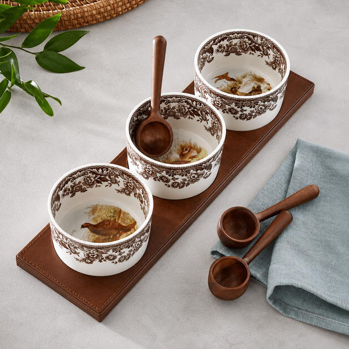 Spode Woodland 7-piece condiment set with three porcelain pots, animal motifs, wooden spoons, and a brown rectangular tray.