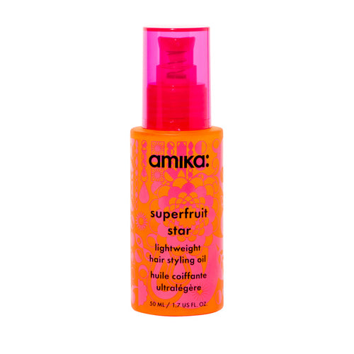 A bottle of Amika Superfruit Star Lightweight Styling Oil with a pink cap and orange label, displaying the product name and description.