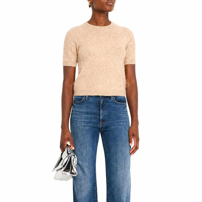 Beige cropped short-sleeve crewneck sweater in soft 100% cashmere with ribbed trim, worn with blue high-waisted jeans.