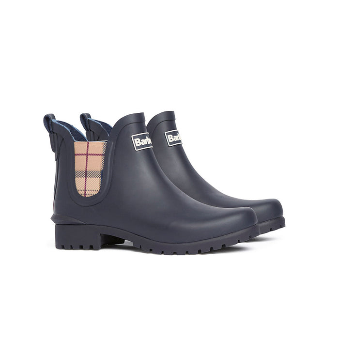 Navy blue Barbour Chelsea wellington boots with a tartan side panel, lug sole, and branded logo on a white background.