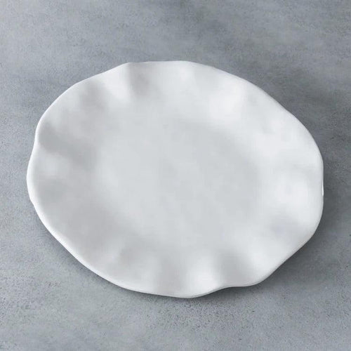Beatriz Ball Vida Havana 11-inch white melamine dinner plate with a wavy, organic edge on a grey background.