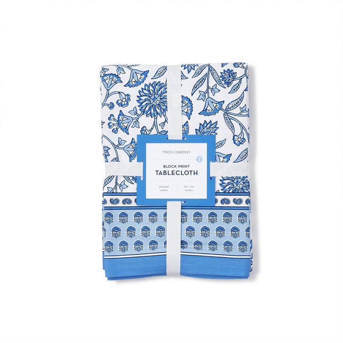 Folded 60x90 inch cotton tablecloth with a blue and white floral chinoiserie block print design and branded paper band.