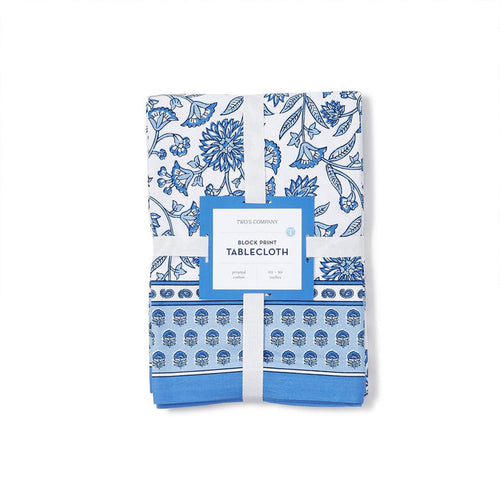 Folded 60x90 inch cotton tablecloth with a blue and white floral chinoiserie block print design and branded paper band.
