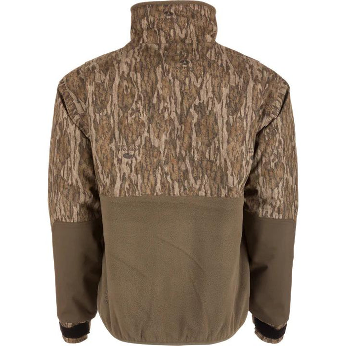 Drake Waterfowl MST Eqwader half-zip jacket in Mossy Oak camo with a brown fleece lower back and reinforced sleeves.