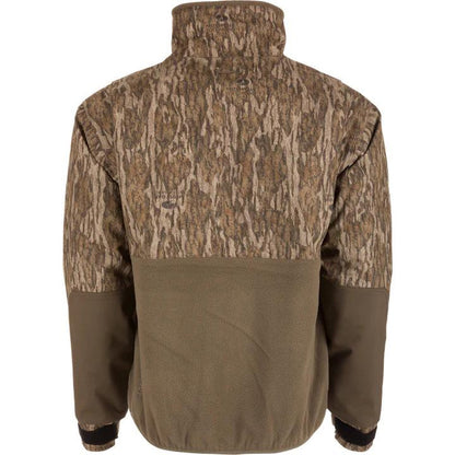 Drake Waterfowl MST Eqwader half-zip jacket in Mossy Oak camo with a brown fleece lower back and reinforced sleeves.