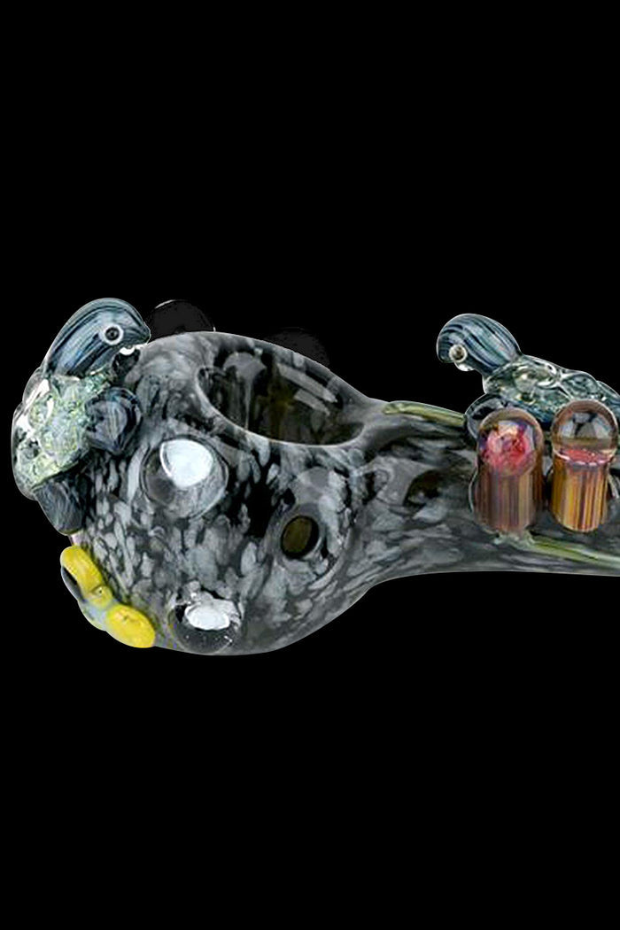 A side view of the Empire Glassworks Spoon Pipe - East Australian Current, featuring swirling blue and green glass patterns.