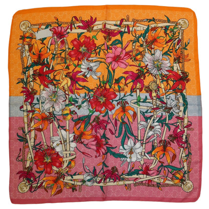 27-inch square polyester twill scarf featuring a vibrant floral lily print with orange and pink color-blocked borders.