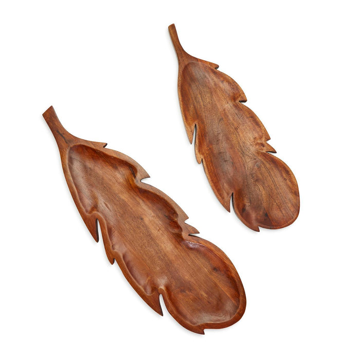 Two handcrafted acacia wood charcuterie boards shaped like feathers in varying sizes with natural wood grain.