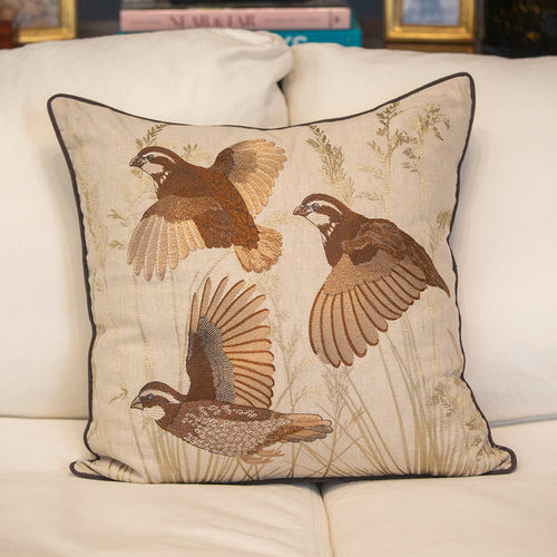 22-inch beige linen pillow cover featuring detailed embroidered flying quail motifs and a tailored dark cording border.