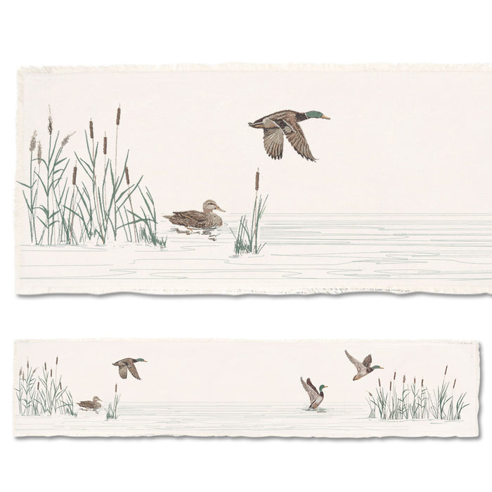 Cotton table runner featuring embroidered mallard ducks in flight and on water with cattails on a cream background.