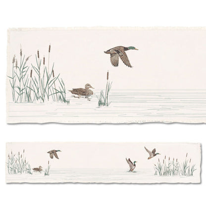 Cotton table runner featuring embroidered mallard ducks in flight and on water with cattails on a cream background.