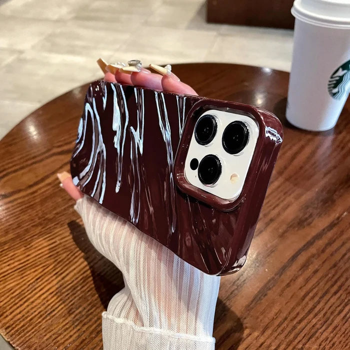 Maroon phone case with white swirls.