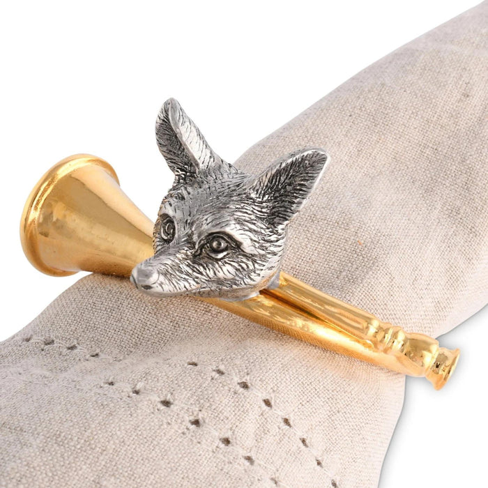 Pewter fox head napkin ring on a gold-tone hunting horn, styled on a beige linen napkin.