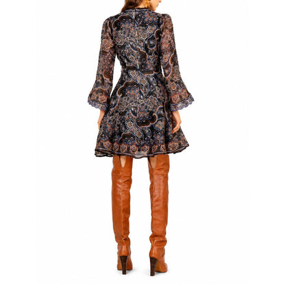Hale Bob Artemis short dress with 3/4 sleeves, featuring a black paisley print and a tie belt, worn with tan boots.