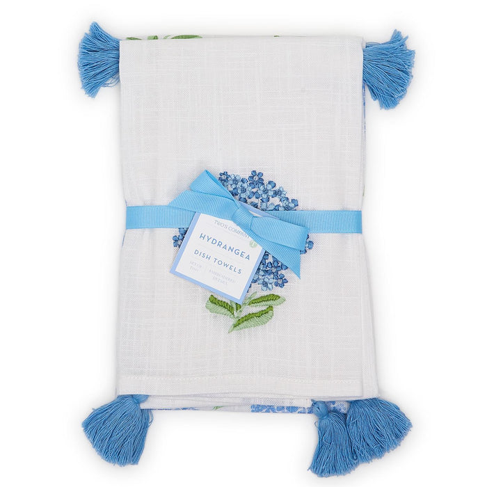 Set of two white cotton dish towels featuring blue hydrangea patterns and decorative blue corner tassels.