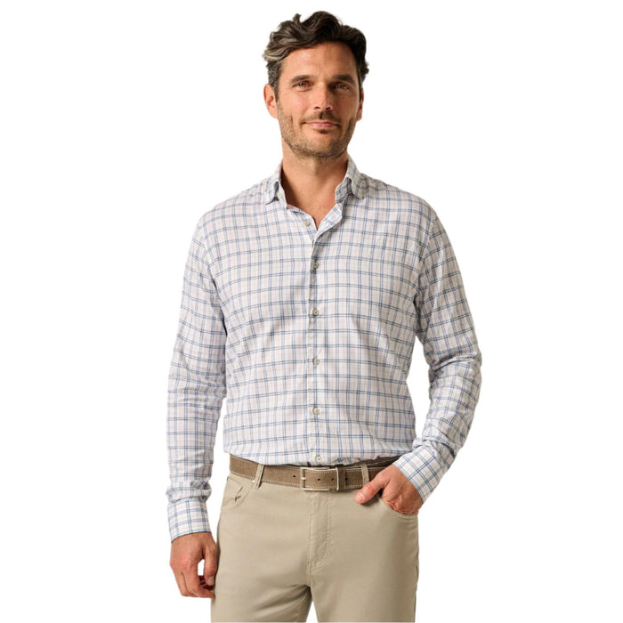 Man wearing a white and blue plaid long-sleeve button-up shirt with a cutaway collar and tan trousers.