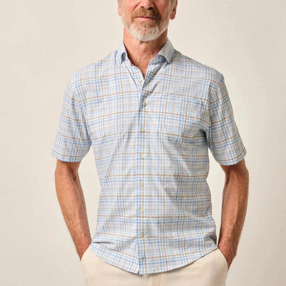 Man wearing a blue and tan plaid short-sleeve performance button-up shirt with a button-down collar.