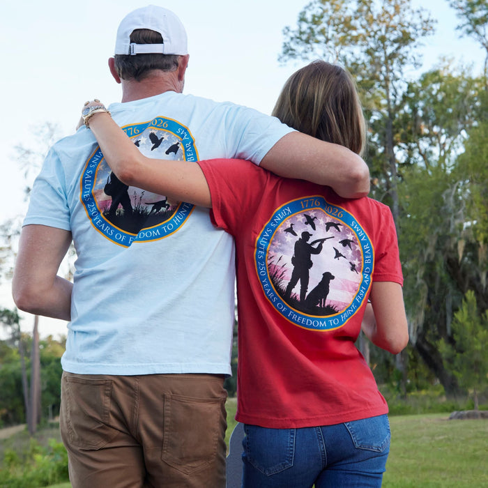 Couple wearing light blue and red Comfort Colors cotton t-shirts with 250 Years of Freedom hunting graphic prints.
