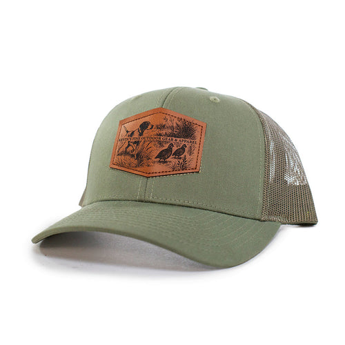 Olive green Richardson 112 trucker cap with a brown leather patch featuring an embossed quail and pointer dog scene.