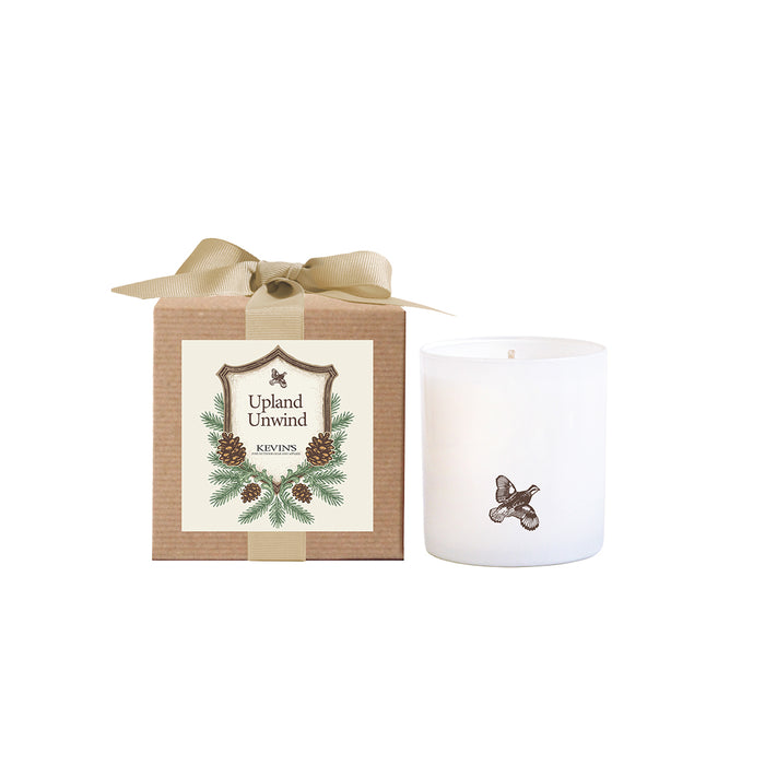 White soy candle with a bird icon next to a kraft gift box featuring a pinecone label and a tan ribbon bow.