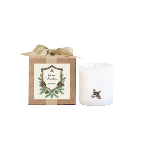 White soy candle with a bird icon next to a kraft gift box featuring a pinecone label and a tan ribbon bow.