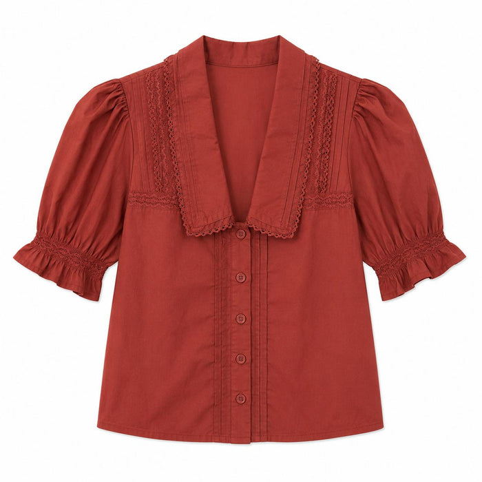 Rust-colored cotton cambric blouse with a V-neck collar, button-down front, and ruffled short sleeves.