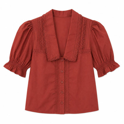 Rust-colored cotton cambric blouse with a V-neck collar, button-down front, and ruffled short sleeves.