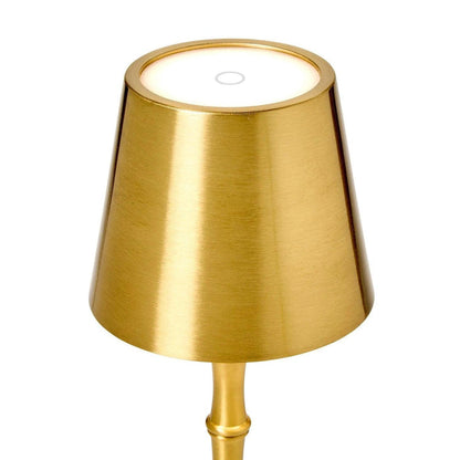 Cordless gold metal table lamp with a bamboo-style base and a sleek, modern tapered shade with integrated LED light.