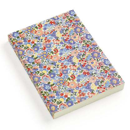 The Liberty London Liberty Nell, Annie and May Premium A5 Notebook has a closed cover with a colorful floral pattern of blue, red, yellow, and pink flowers, displayed on a white background.