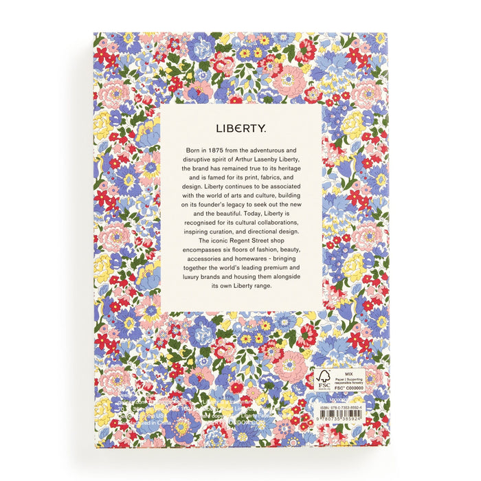 The image shows the back cover of the Liberty Nell, Annie and May Premium A5 Notebook by Liberty London, featuring a vibrant floral pattern. A central white box details Libertys heritage and reputation for prints and design.