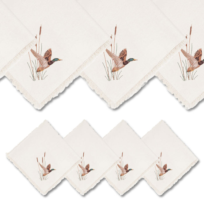 Set of four off-white linen napkins featuring embroidered mallard duck designs and decorative fringe edges.