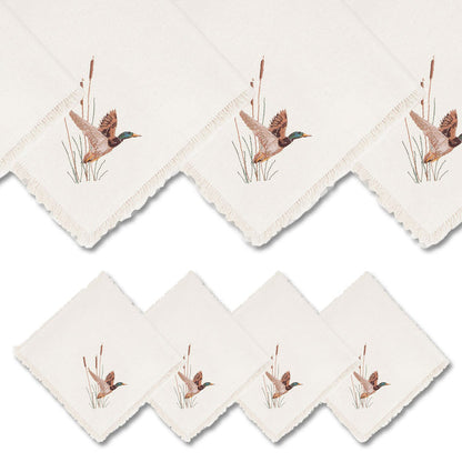 Set of four off-white linen napkins featuring embroidered mallard duck designs and decorative fringe edges.