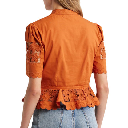 Cinnamon-colored peplum top with puff sleeves and intricate floral cutwork lace detailing on the hem and sleeves.
