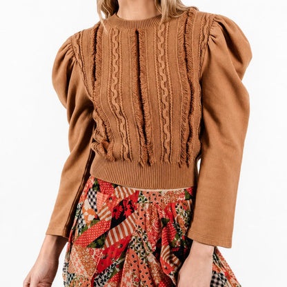 Caramel-colored cotton knit pullover with sculpted puff sleeves, cable-knit detailing, and a ribbed hem.