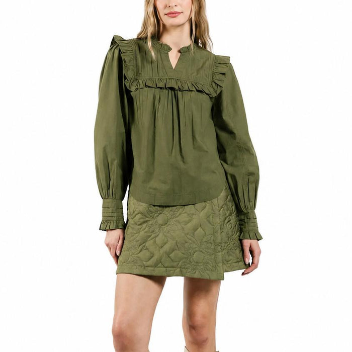 Olive green Tallulah blouse with a V-neck, delicate pleating, and ruffle trim on the yoke and cuffs.