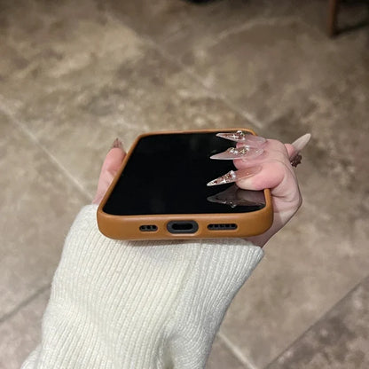Brown-cased smartphone with long, decorated fingernails.