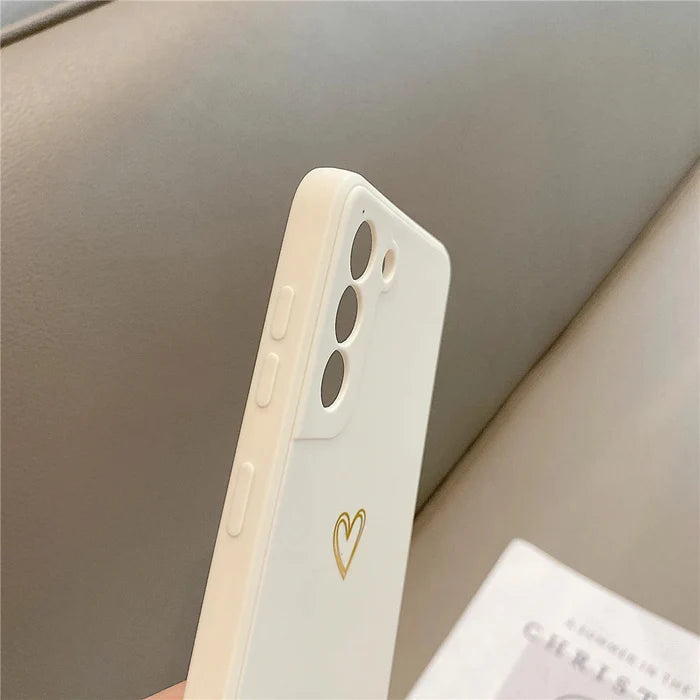 White phone case with a gold heart design