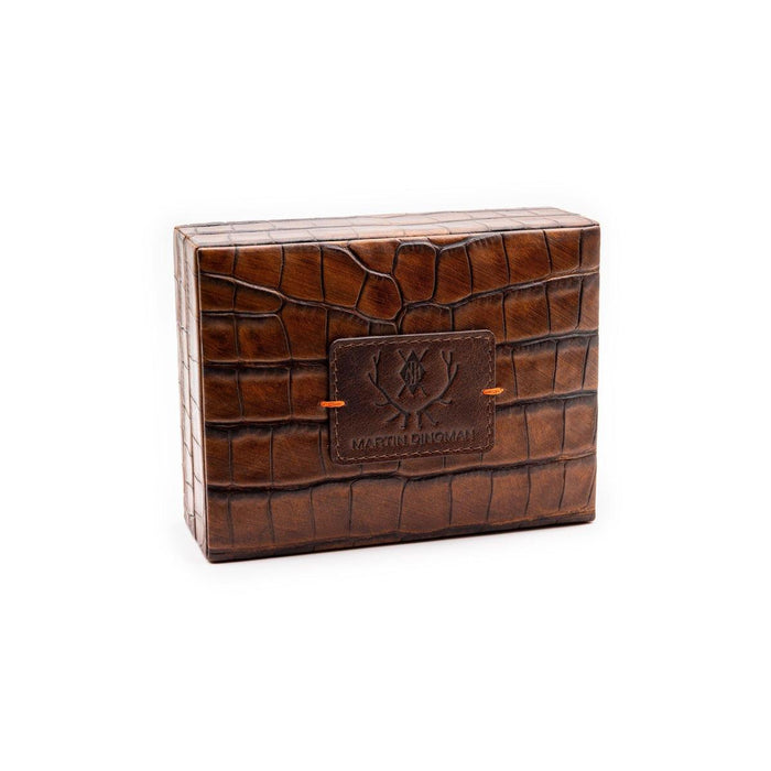 Brown alligator grain leather playing card case by Martin Dingman with a branded logo patch and orange accent stitching.