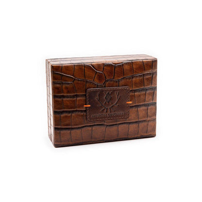 Brown alligator grain leather playing card case by Martin Dingman with a branded logo patch and orange accent stitching.