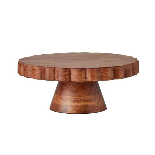 Round scalloped cake stand crafted from rich, natural acacia wood with a sturdy pedestal base and unique grain patterns.