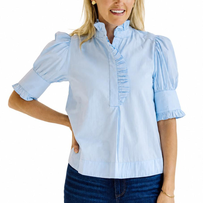 Light blue cotton poplin top with puff sleeves, a ruffled stand collar, and a button placket.