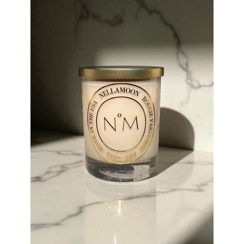 Nellamoon 13.5 oz Juliette soy candle in a clear glass jar with a gold lid and elegant gold circular label on marble.