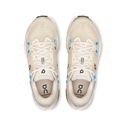 Top-down view of beige On Running Cloudsurfer 2 women's shoes with breathable mesh and bright blue eyelet accents.