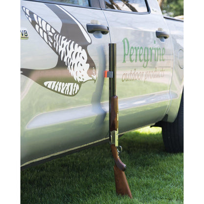 Compact grey magnetic gun caddy holding a shotgun upright against the side of a silver vehicle.